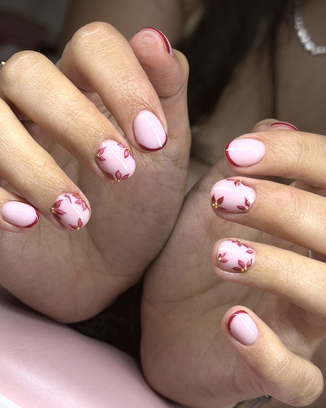 Uñas cortas rosas con hojas rojas