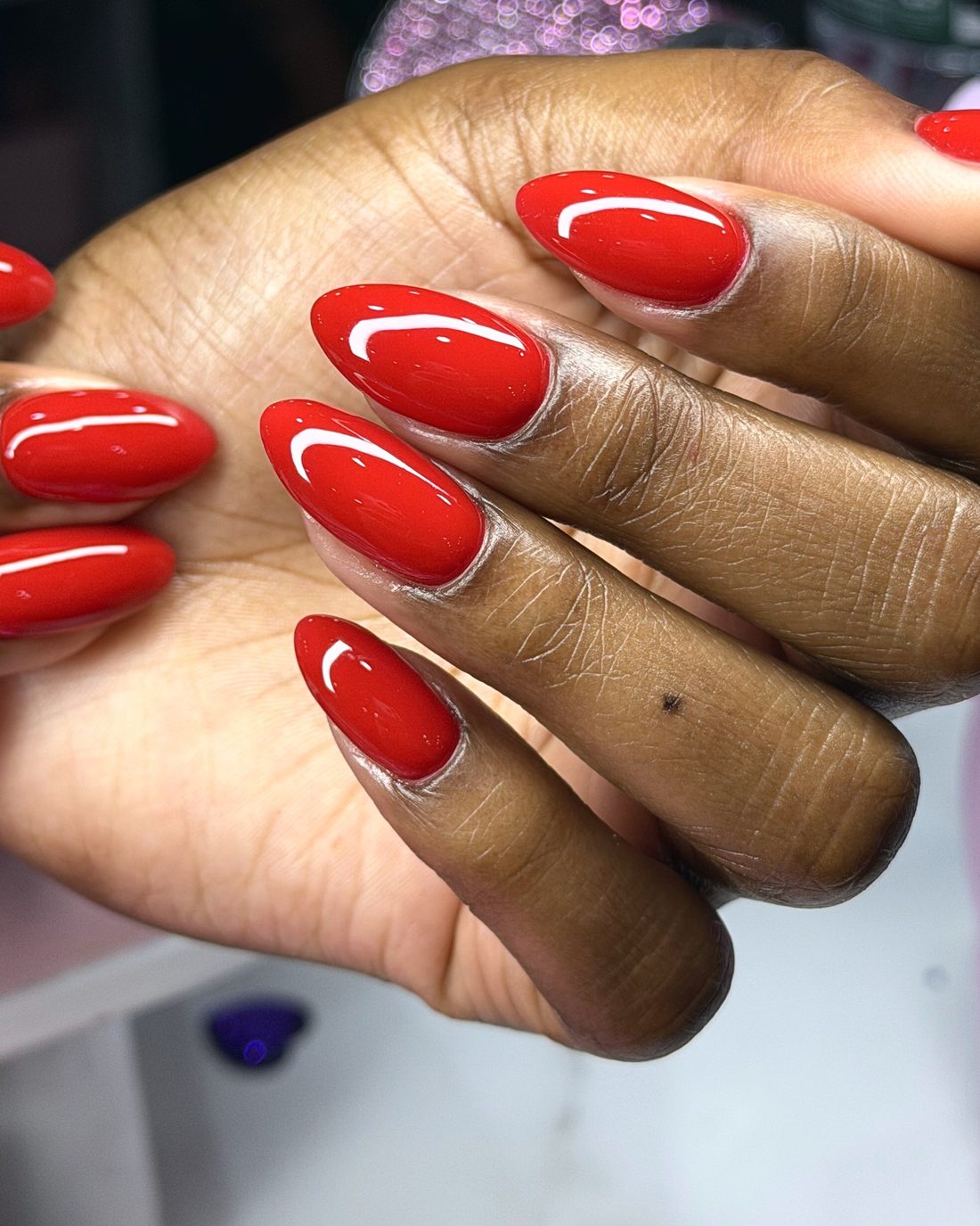 Manicura en gel roja brillante, forma almendra